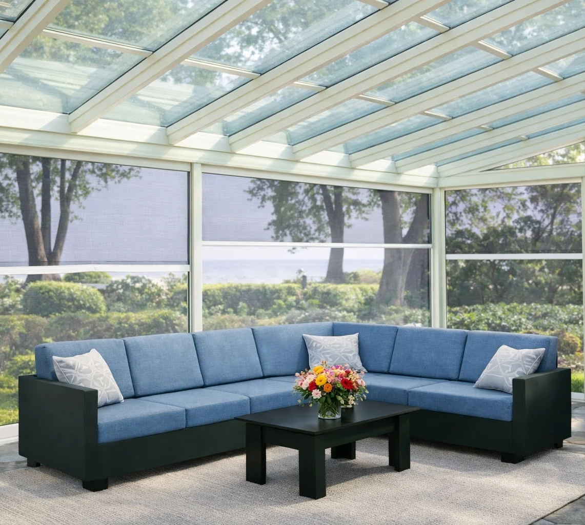 Sunroom interior with glass roof and comfortable blue sectional sofa